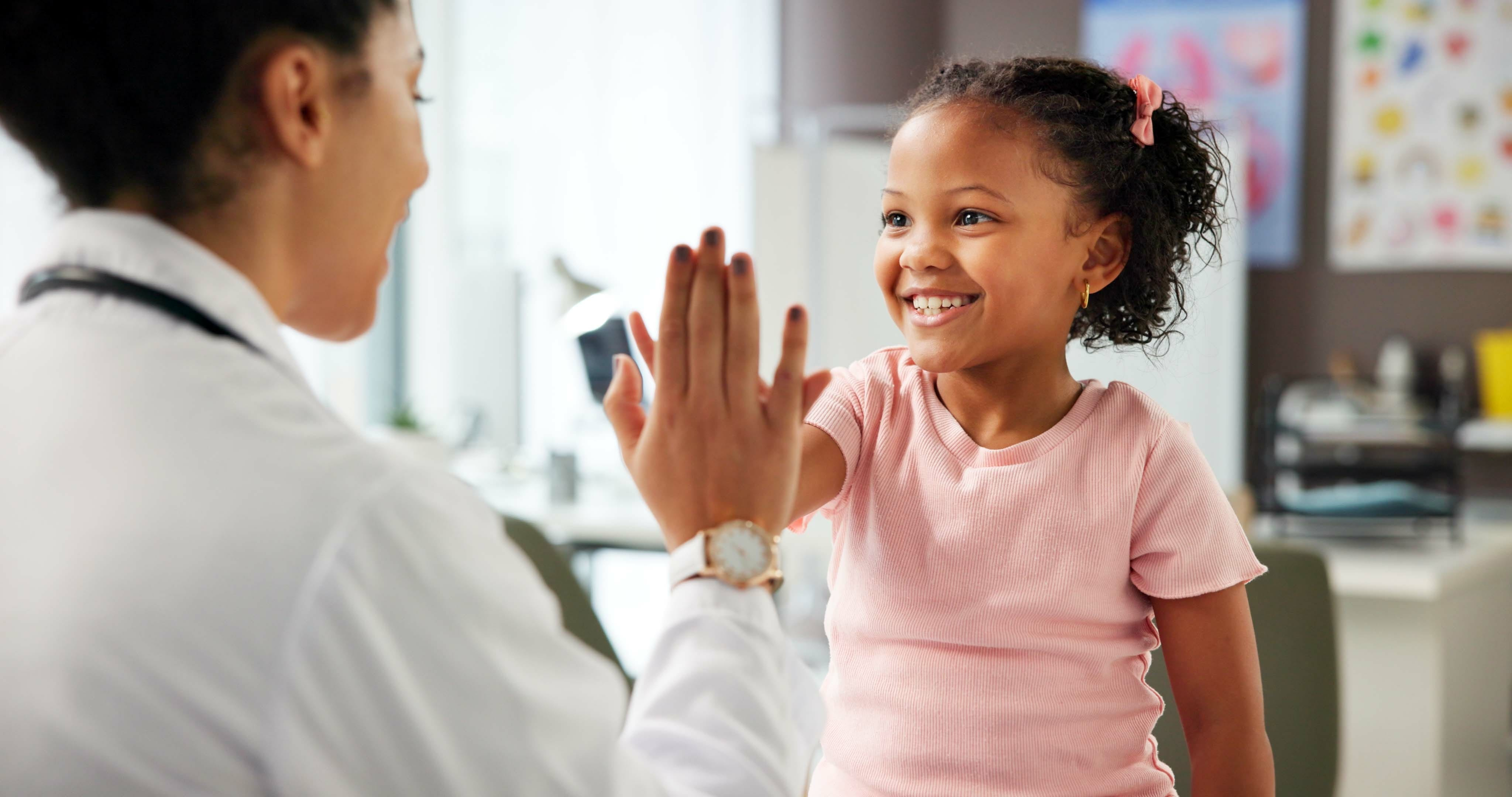 little girl giving a high five to her doctor